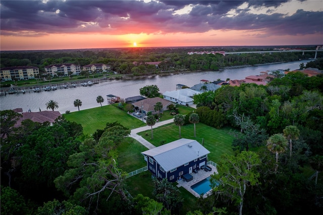 aerial view at dusk featuring a water view