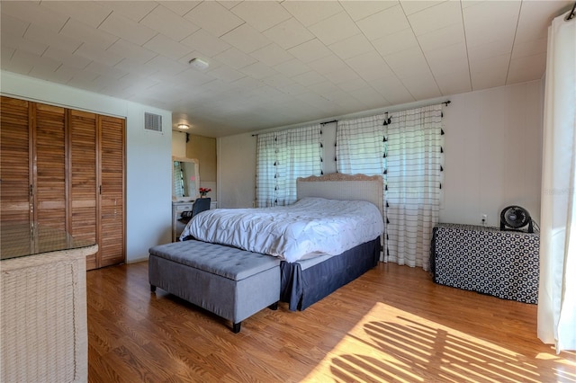 bedroom featuring wood finished floors, a closet, and visible vents