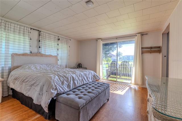 bedroom featuring access to outside and wood finished floors