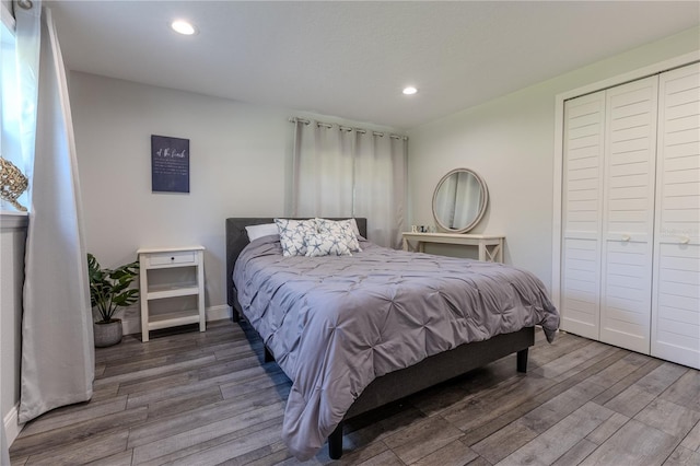 bedroom with recessed lighting, a closet, baseboards, and wood finished floors