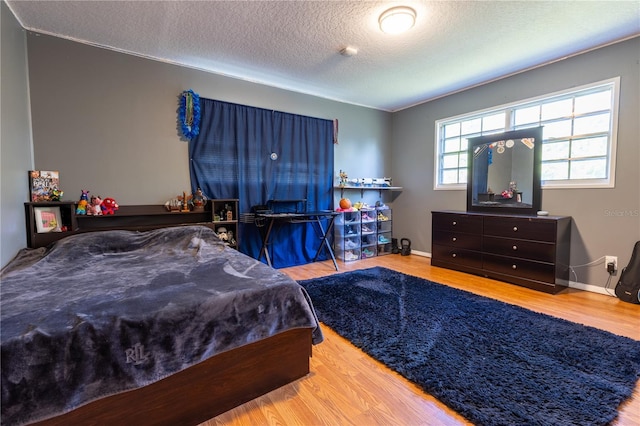 bedroom with wood finished floors and a textured ceiling