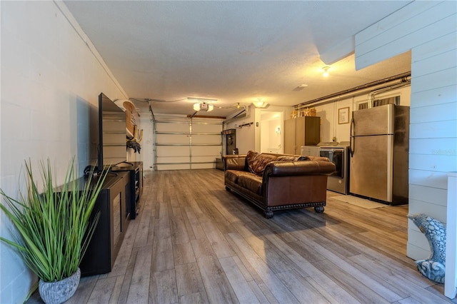 garage featuring washer / dryer and freestanding refrigerator