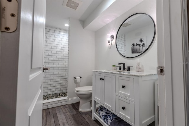 full bathroom featuring vanity, a stall shower, toilet, visible vents, and wood finished floors