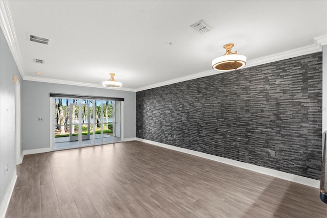 spare room with baseboards, crown molding, and wood finished floors