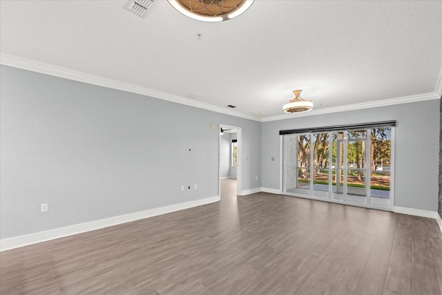 unfurnished room featuring ornamental molding, baseboards, and wood finished floors