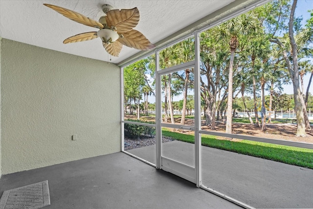 unfurnished sunroom featuring ceiling fan and healthy amount of natural light