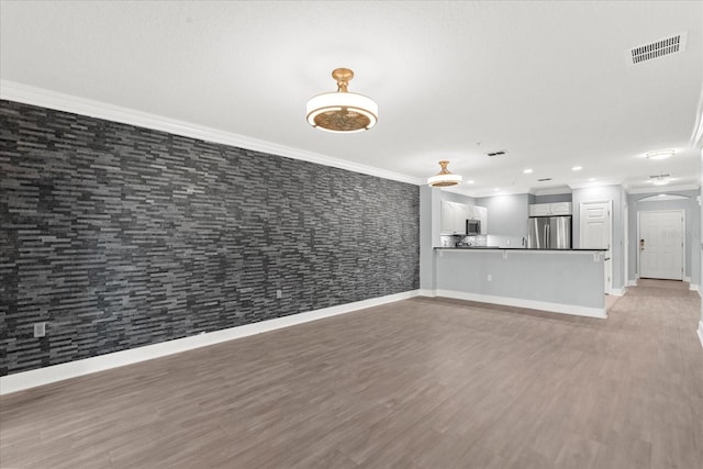 unfurnished living room featuring ornamental molding, baseboards, light wood-type flooring, arched walkways, and recessed lighting