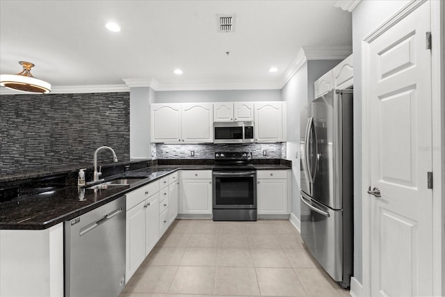 kitchen featuring stainless steel appliances, a sink, backsplash, crown molding, and white cabinetry