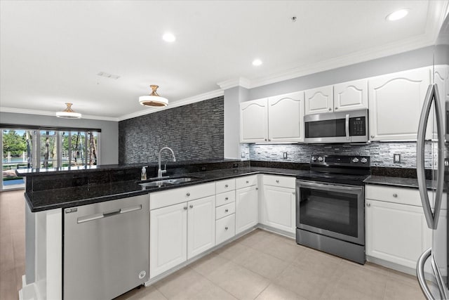 kitchen featuring appliances with stainless steel finishes, a sink, a peninsula, white cabinets, and decorative backsplash