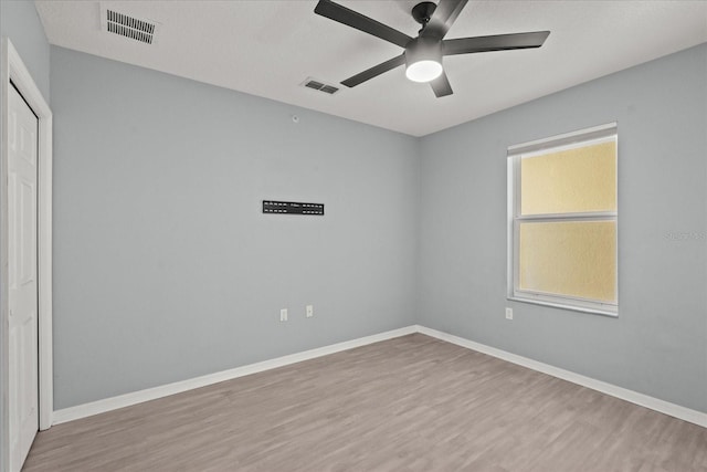 unfurnished room featuring wood finished floors, a ceiling fan, and baseboards