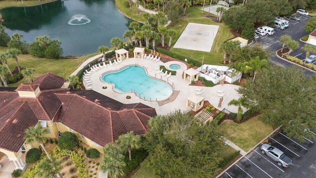 drone / aerial view of a pool area and a nearby body of water