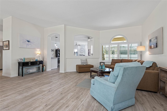 65 Esperanto Dr, Palm Coast, FL 32164 - living room with arched walkways, light wood-style floors, a ceiling fan, and baseboards