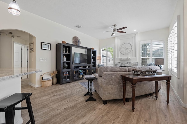 65 Esperanto Dr, Palm Coast, FL 32164 - living area with visible vents, arched walkways, baseboards, light wood-style flooring, and ceiling fan