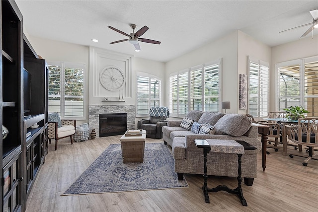 65 Esperanto Dr, Palm Coast, FL 32164 - living area with plenty of natural light, a ceiling fan, a stone fireplace, and wood finished floors