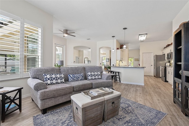 65 Esperanto Dr, Palm Coast, FL 32164 - living area with arched walkways, a ceiling fan, and light wood-style floors