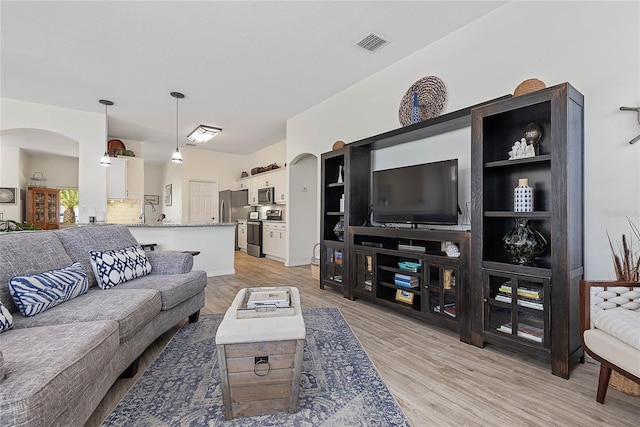 65 Esperanto Dr, Palm Coast, FL 32164 - living room with arched walkways, visible vents, and light wood finished floors