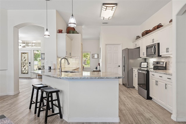 65 Esperanto Dr, Palm Coast, FL 32164 - kitchen with arched walkways, tasteful backsplash, white cabinets, and stainless steel appliances