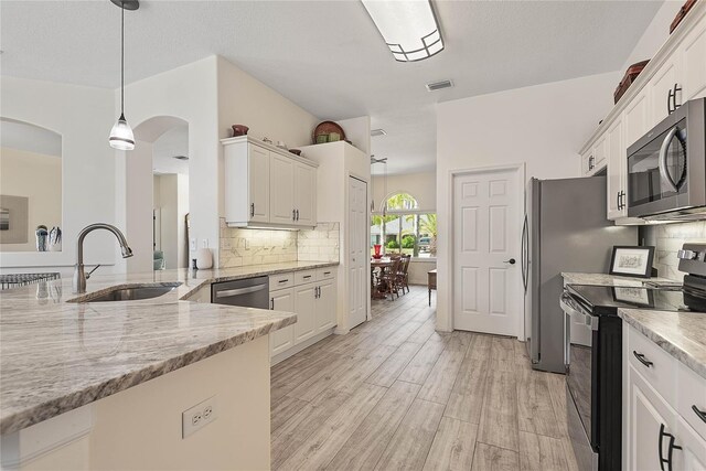 65 Esperanto Dr, Palm Coast, FL 32164 - kitchen featuring a sink, arched walkways, stainless steel appliances, white cabinetry, and visible vents