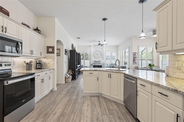 65 Esperanto Dr, Palm Coast, FL 32164 - kitchen with a ceiling fan, a sink, light wood-type flooring, stainless steel appliances, and backsplash