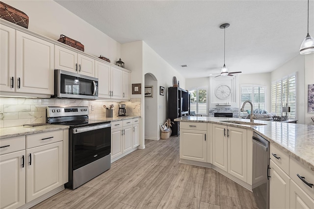 65 Esperanto Dr, Palm Coast, FL 32164 - kitchen with a sink, light wood-type flooring, tasteful backsplash, appliances with stainless steel finishes, and ceiling fan
