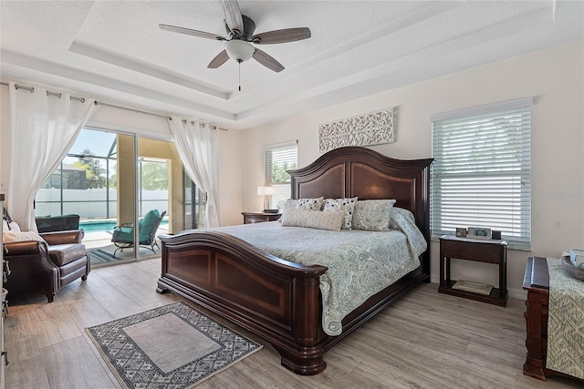 65 Esperanto Dr, Palm Coast, FL 32164 - bedroom featuring a raised ceiling, light wood finished floors, a ceiling fan, and access to outside