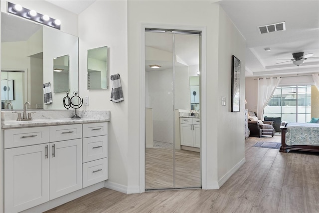 65 Esperanto Dr, Palm Coast, FL 32164 - ensuite bathroom featuring wood finished floors, connected bathroom, ceiling fan, baseboards, and visible vents