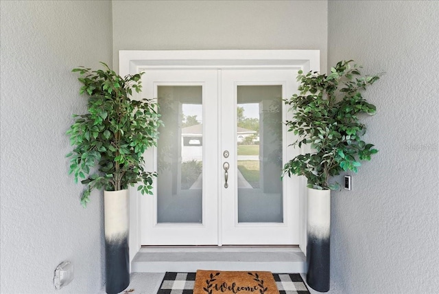 40 Woodborn Ln, Palm Coast, FL 32164 - view of exterior entry featuring french doors and stucco siding