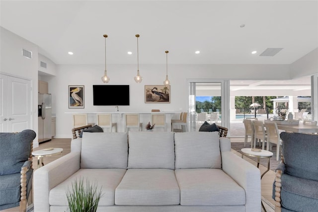 living room with recessed lighting, visible vents, and light wood finished floors
