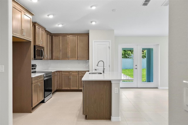 55 Ryan Dr, Palm Coast, FL 32164 - kitchen with appliances with stainless steel finishes, a sink, decorative backsplash, light countertops, and a center island with sink