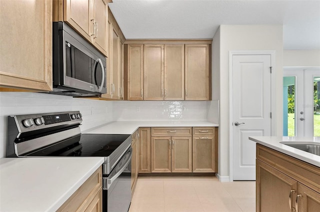55 Ryan Dr, Palm Coast, FL 32164 - kitchen featuring stainless steel appliances, tasteful backsplash, light countertops, and light tile patterned floors