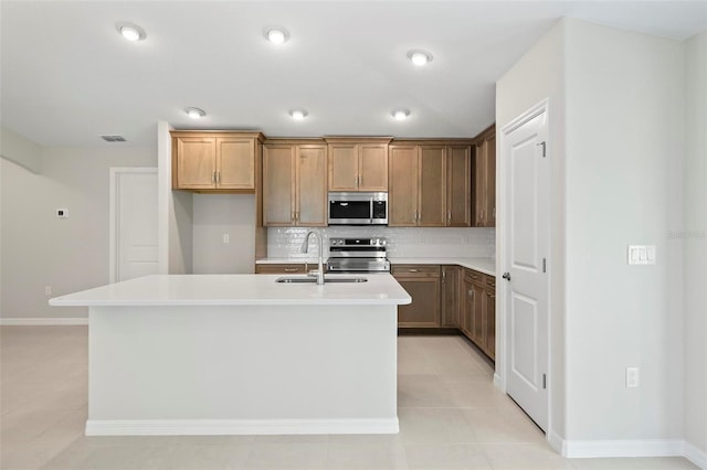 55 Ryan Dr, Palm Coast, FL 32164 - kitchen with appliances with stainless steel finishes, a sink, backsplash, an island with sink, and light countertops