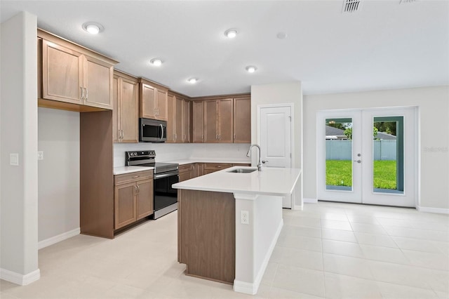 55 Ryan Dr, Palm Coast, FL 32164 - kitchen featuring appliances with stainless steel finishes, a sink, light countertops, baseboards, and an island with sink