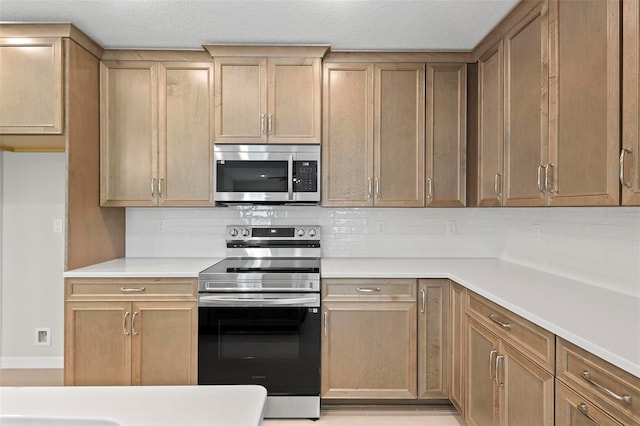 55 Ryan Dr, Palm Coast, FL 32164 - kitchen featuring stainless steel appliances, backsplash, light countertops, and baseboards