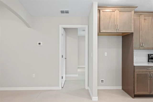 55 Ryan Dr, Palm Coast, FL 32164 - kitchen with backsplash, light countertops, baseboards, and light tile patterned floors