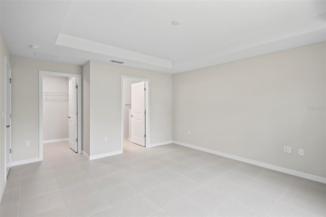55 Ryan Dr, Palm Coast, FL 32164 - unfurnished bedroom with a walk in closet, a closet, baseboards, and light tile patterned floors