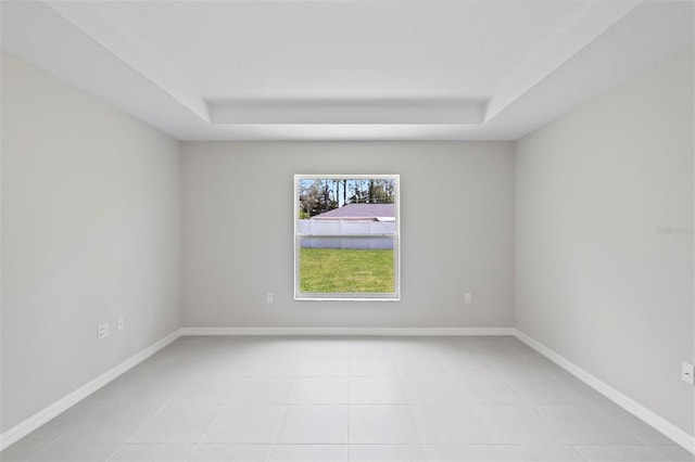 55 Ryan Dr, Palm Coast, FL 32164 - unfurnished room featuring a tray ceiling, light tile patterned flooring, and baseboards