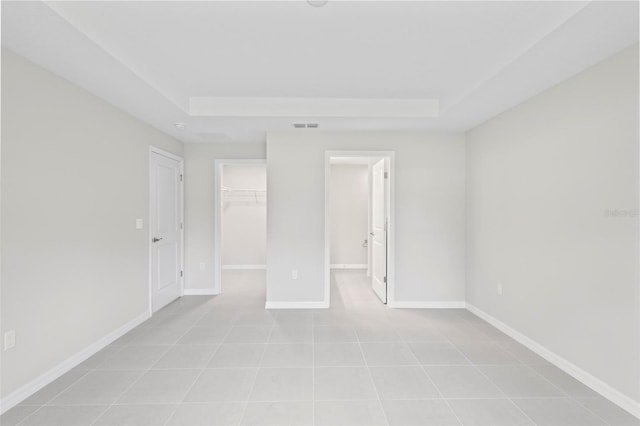 55 Ryan Dr, Palm Coast, FL 32164 - empty room featuring a raised ceiling, baseboards, and light tile patterned floors