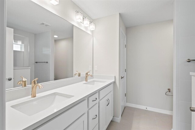 55 Ryan Dr, Palm Coast, FL 32164 - bathroom with double vanity, baseboards, tile patterned flooring, and a tile shower