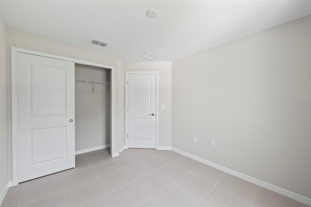 55 Ryan Dr, Palm Coast, FL 32164 - unfurnished bedroom with baseboards, light tile patterned flooring, and a closet