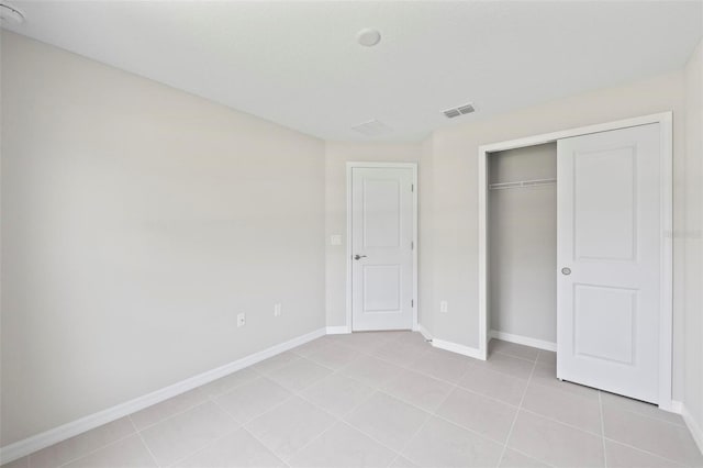 55 Ryan Dr, Palm Coast, FL 32164 - unfurnished bedroom with light tile patterned floors, baseboards, and a closet