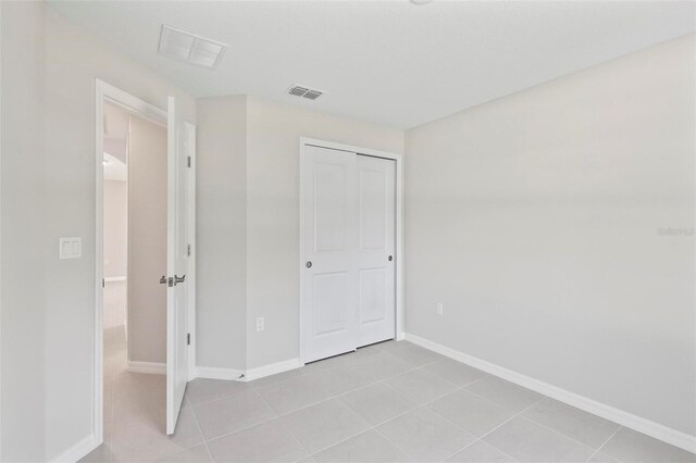 55 Ryan Dr, Palm Coast, FL 32164 - unfurnished bedroom featuring light tile patterned flooring, a closet, and baseboards