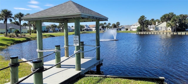 view of dock with a residential view and a water view
