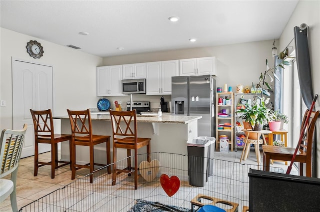 47 Raleigh Dr, Palm Coast, FL 32164 - kitchen with light tile patterned floors, white cabinets, visible vents, stainless steel appliances, and recessed lighting