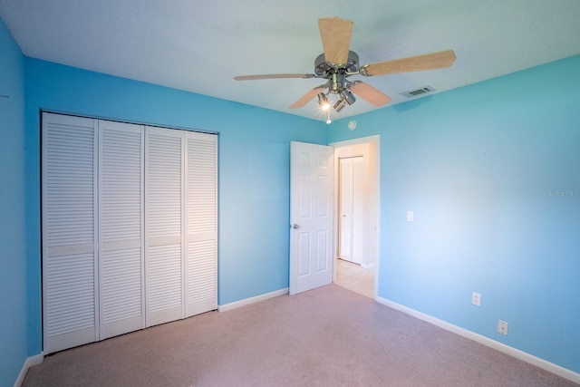 unfurnished bedroom featuring baseboards, a closet, carpet flooring, and visible vents