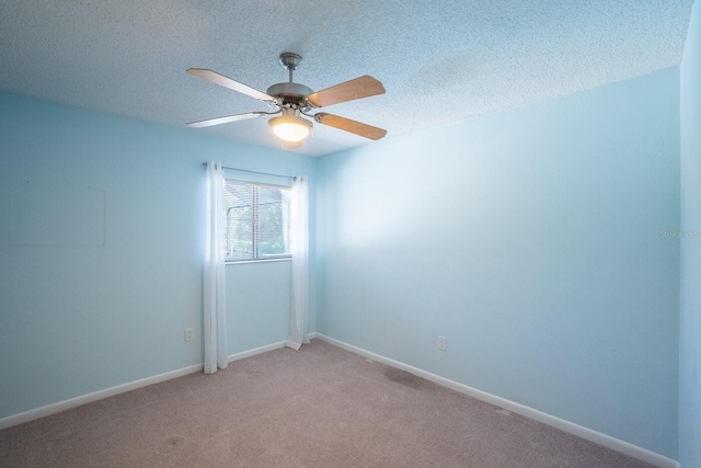 empty room featuring baseboards, ceiling fan, a textured ceiling, and light colored carpet