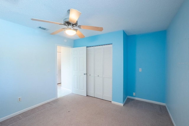 unfurnished bedroom with light colored carpet, baseboards, visible vents, and a closet
