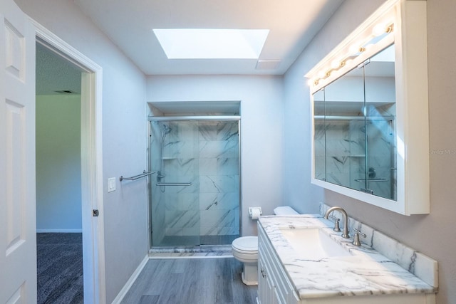 full bathroom with a marble finish shower, wood finished floors, a skylight, and toilet