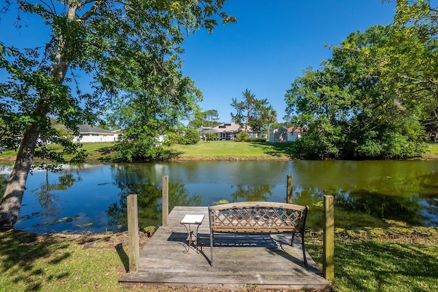 view of dock with a water view and a yard