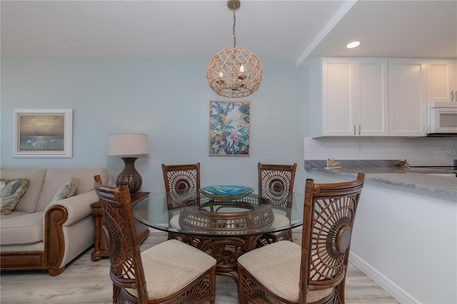 1155 Ocean Shore Blvd Unit 702, Ormond Beach, FL 32176 - dining area featuring light wood-style flooring, a textured ceiling, baseboards, recessed lighting, and a chandelier