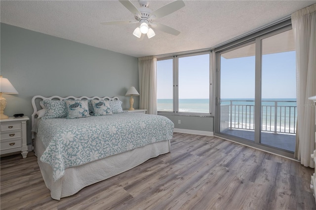 1155 Ocean Shore Blvd Unit 702, Ormond Beach, FL 32176 - bedroom with wood finished floors, a textured ceiling, a water view, and access to exterior